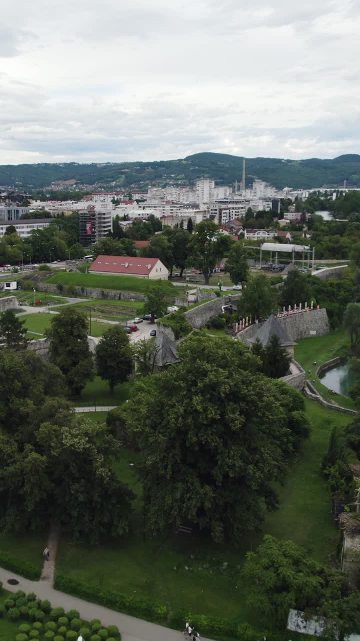 Aerial view of the Srpska Pravoslavna Crkva - Serbian Orthodox Church - located in Banja Luka, Bosnia and Herzegovina, featuring surrounding buildings and green spaces. Vertical Video, Dolly Back