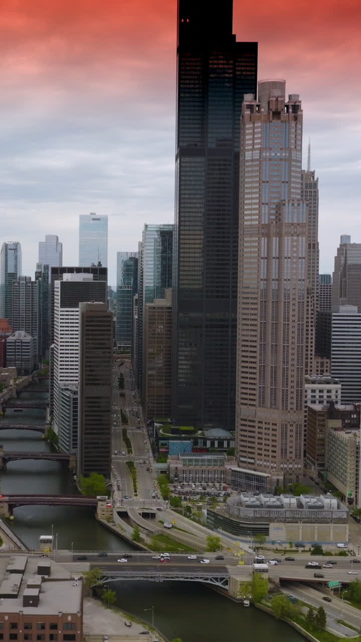 Transport traffic on the roads of busy Chicago at daytime. Beautiful skyscrapers towering over the streets of metropolis. Top view. Vertical video