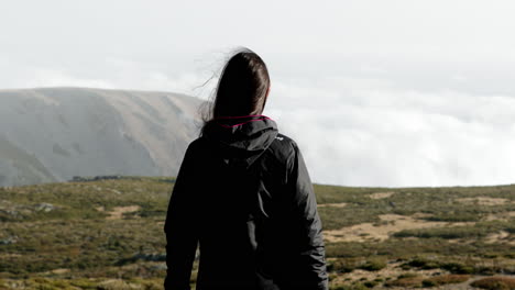 una mujer camina y disfruta de su libertad en el pico de la montaña serra da estrela en portugal - cerrar