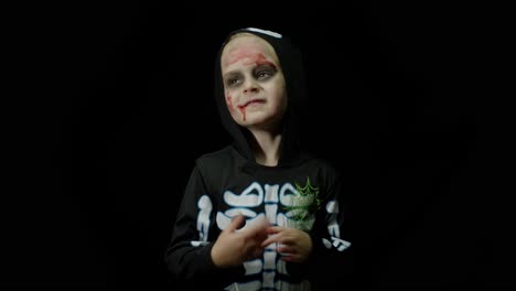 Halloween-angry-girl-with-blood-makeup-on-face.-Kid-dressed-as-scary-skeleton,-dancing,-making-faces