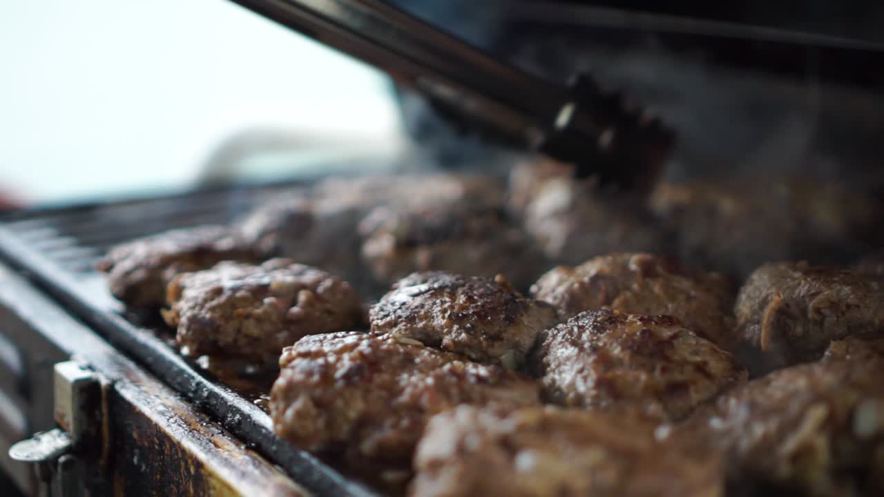 SLOWMO - Lo chef prepara succosi hamburger sulla griglia