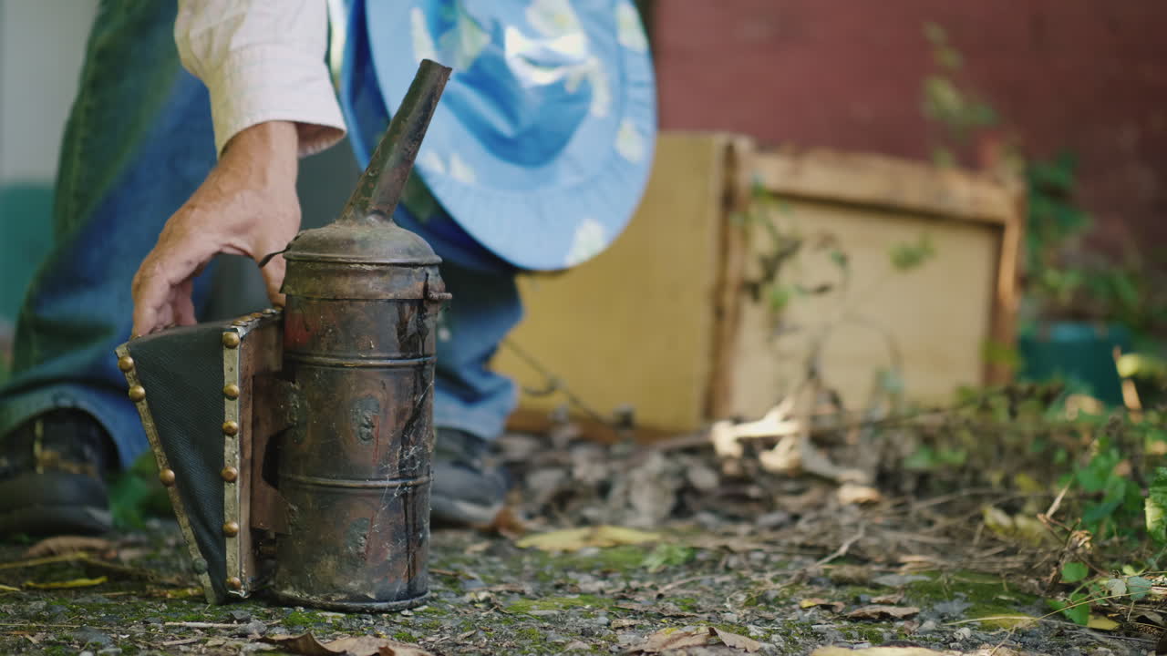 el apicultor prepara una máquina de humo para trabajar en el colmenar video 4k
