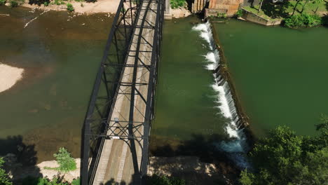 Establishing-shot-of-War-eagle-bridge,-tilt-up-reveals-red-mill-across-creek