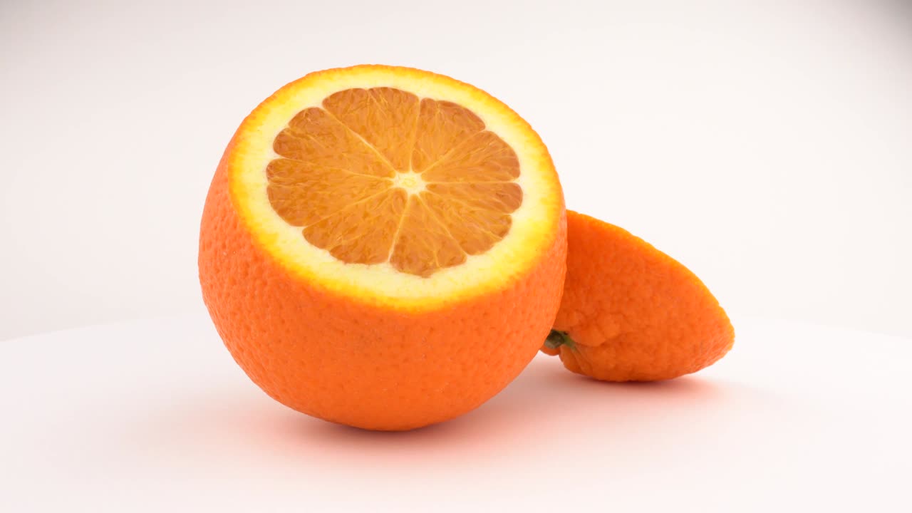 frutas de naranja jugosas cortadas girando. aisladas sobre un fondo blanco. loopable. vista desde arriba o por encima. macro de cerca.