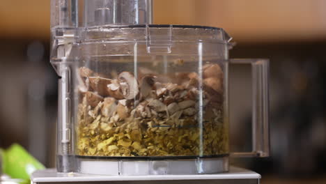 Pulsing-the-food-processor-to-mix-assorted-chopped-mushrooms---isolated-in-slow-motion