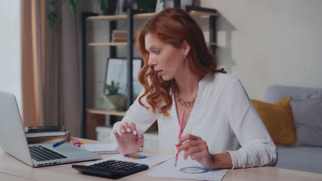 successful caucasian woman focuses on financial audit by going through papers