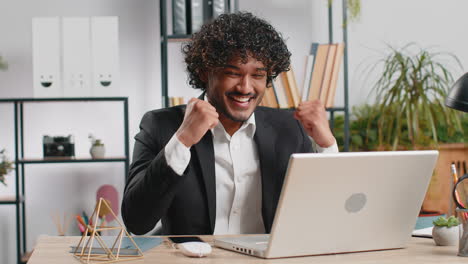 business man winner working browsing typing on laptop at office celebrate big lottery win good news