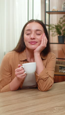 young woman holding coffee cup thinking peacefully with happy calm mood during quiet break morning