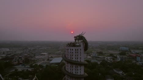 Dragon-encircles-temple-at-sunset-near-Bangkok---aerial-wide-reveal