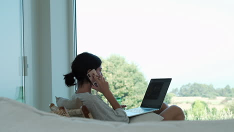 remote work bliss: young woman balances tech and tranquility by window