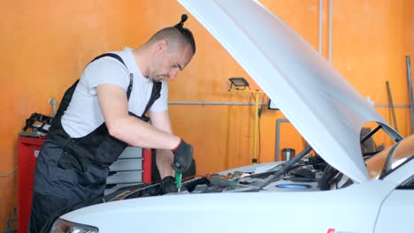 mechanic working on a car engine in an auto repair shop