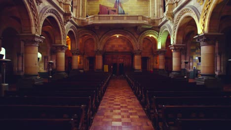 Dolly-in-empty-pews-inside-Los-Sacramentinos-Church-with-giant-disused-organ,-Santiago-Chile