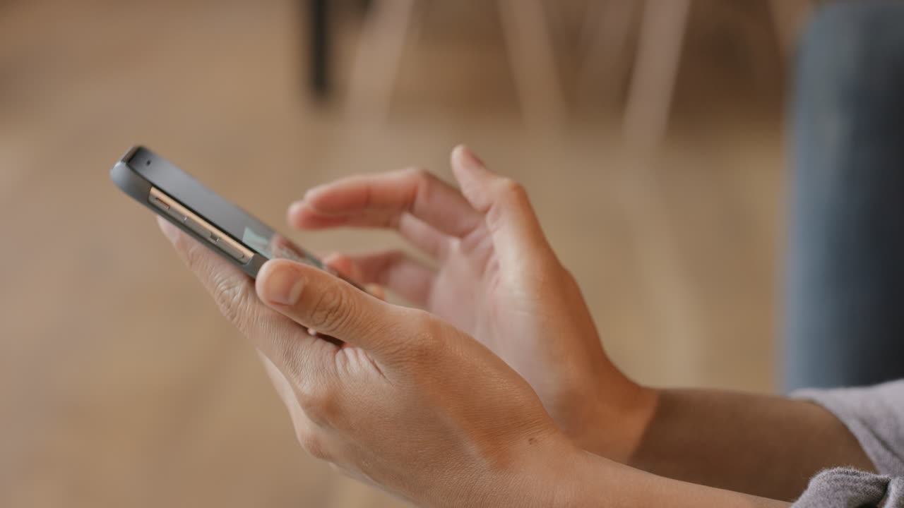 Close up of Woman's flipping through vacation photos on smart phone at home