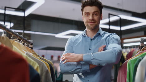 trabajador de la tienda buscando ropa en el primer plano de la boutique. hombre posando retrato de la cámara