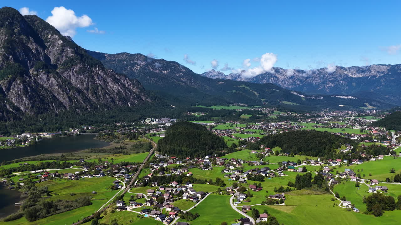Elokuvamainen ilmakuva dronella Altaussee-järvestä ja dramaattisten vuorten ympäröimästä alppikylästä Itävallan Salzkammergutin alueella.