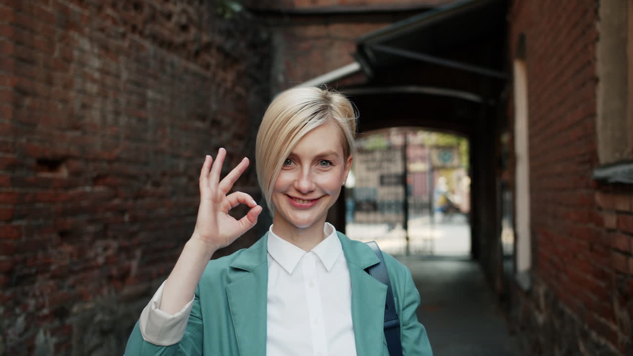 Woman Outdoors, Smiling and Gesturing OK