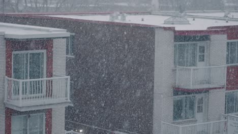 La-Nieve-Fría-Del-Invierno-En-Cámara-Lenta-Cae-Frente-Al-Edificio-De-Apartamentos-Con-Balcones-Y-Ventanas.