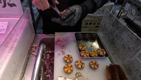 person frying and serving street food snacks.