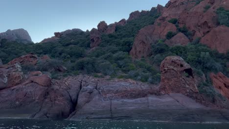 Tour-boat-at-Scandola-UNESCO-nature-reserve-in-summer-season,-Corsica-island-in-France