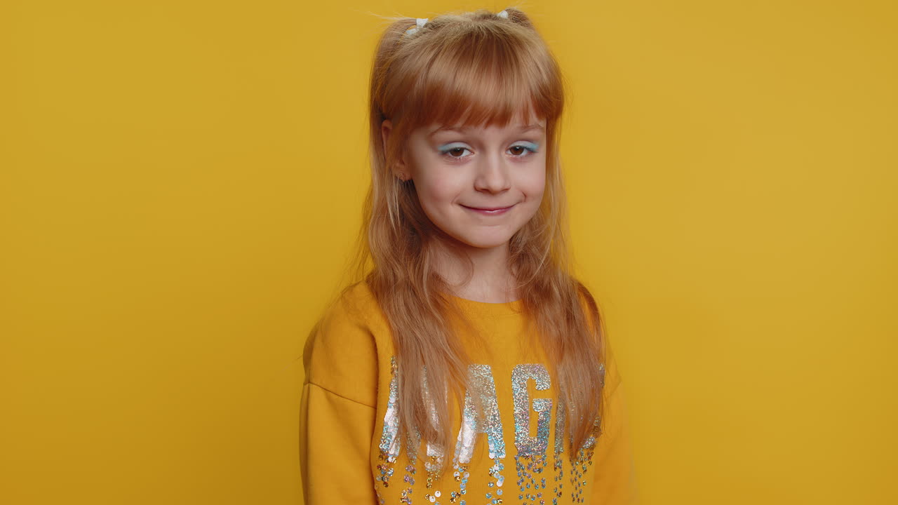 아이 소녀 아이는 흥분하여 미소 짓고 카메라로 손가락을 가리키며 행운의 승자를 선택합니다.