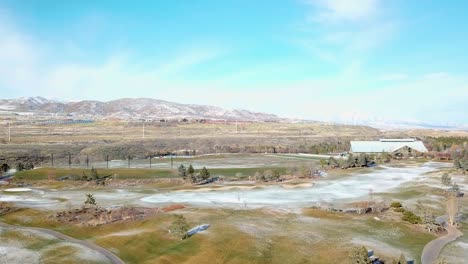 aerial fight over a golf course in early winter with light snow - parallax move