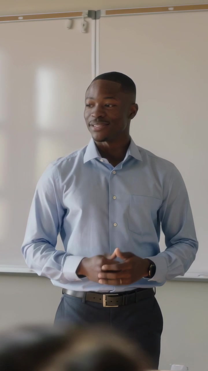 Vertical video: Starting class, teacher speaking and gesturing, leading lesson, blue shirt, board