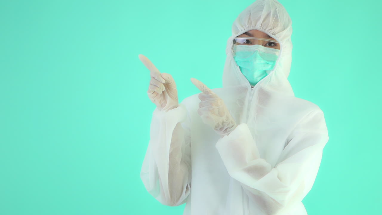 primer plano medio, plantilla joven, trabajador de la salud, con equipo de protección personal completo gestos con ambas manos a un espacio negro para su mensaje