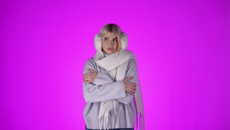 woman is freezing and shaking because of the cold, violet studio background