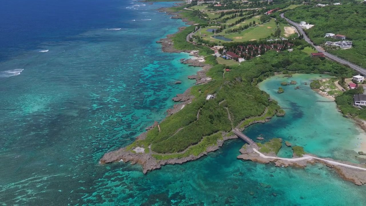Riprese aeree orizzontali in arretramento sopra il Giardino Marino di Imgyaa, Shigira e la costa delimitata dalla barriera corallina con un campo da golf costiero, Miyakojima, Okinawa, Giappone.