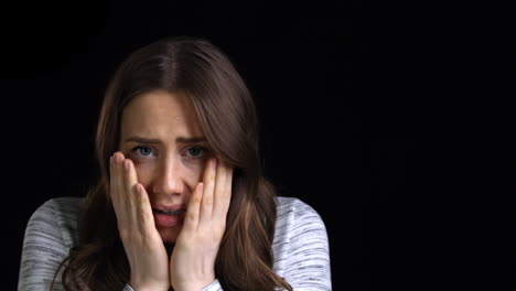 studio shot of scared young woman flinching from abuse