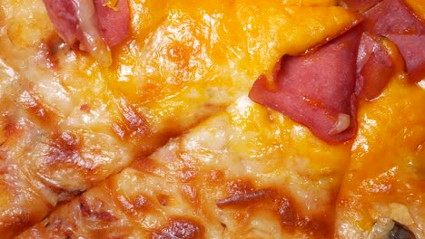 close-up of a cheesy pizza with ham toppings