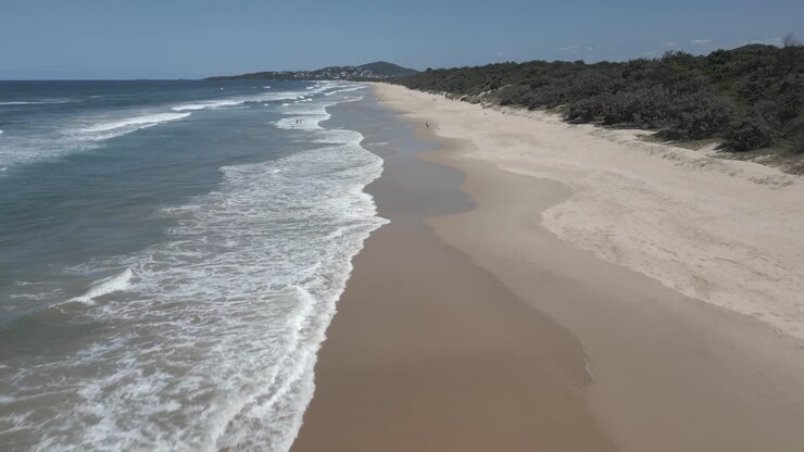 Luftaufnahme: Wellen schlagen sanft an den Sandstrand von Warners Bay, NSW, Australien