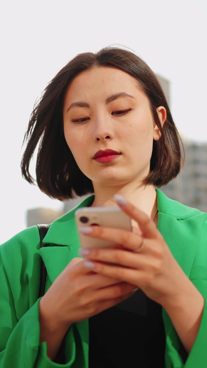 Giovane donna che usa uno smartphone all'aperto in città