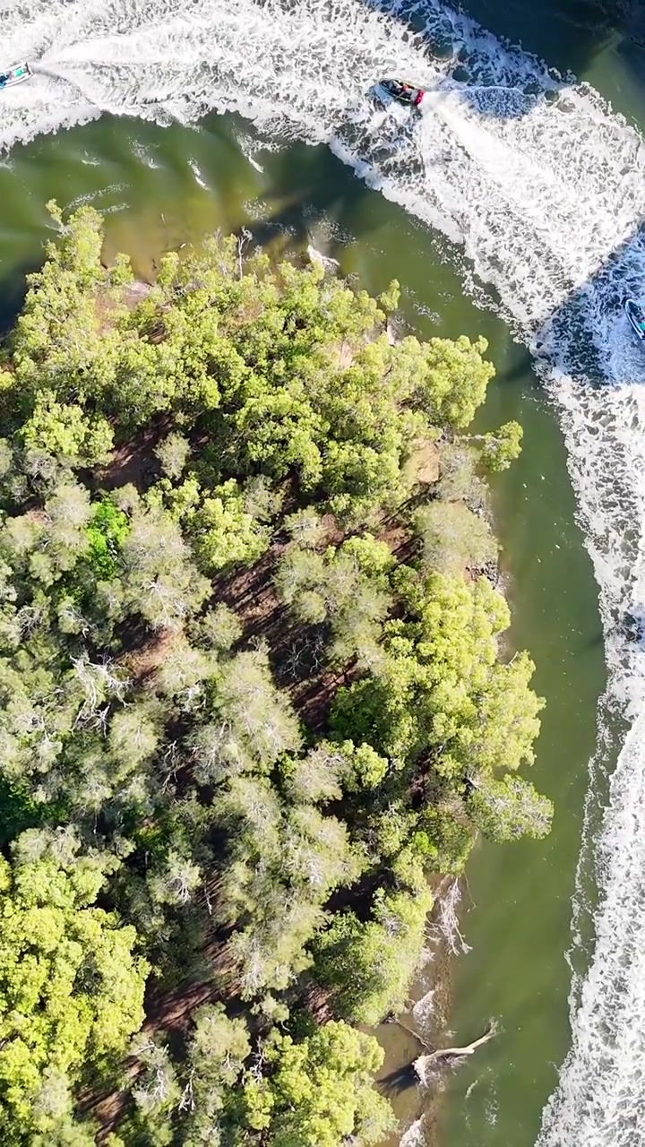 Vista Aérea de Jet Skis Contornando uma Ilha Verde em um Rio