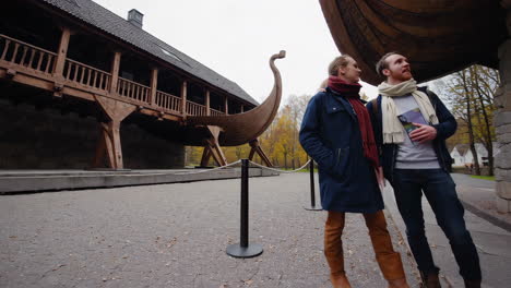 couple exploring a viking ship museum in autumn