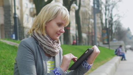 Junge-Frau,-Die-Sich-Im-Park-Ausruht,-Genießt-Ein-Digitales-4k-Tablet-Video