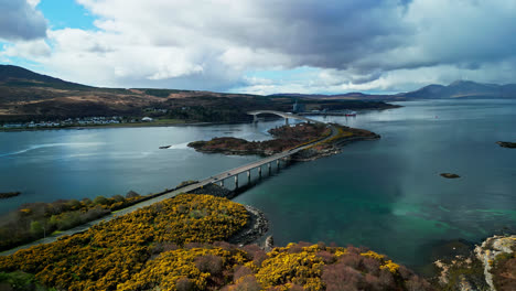 panoramic overview of yellow coastal hillsides leading to the skye bridge in scotland on a cloudy day