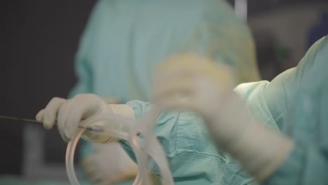 plastic surgeon manipulating tubes during an aesthetic intervention, showcasing precision and expertise in the intricate procedures of cosmetic surgery