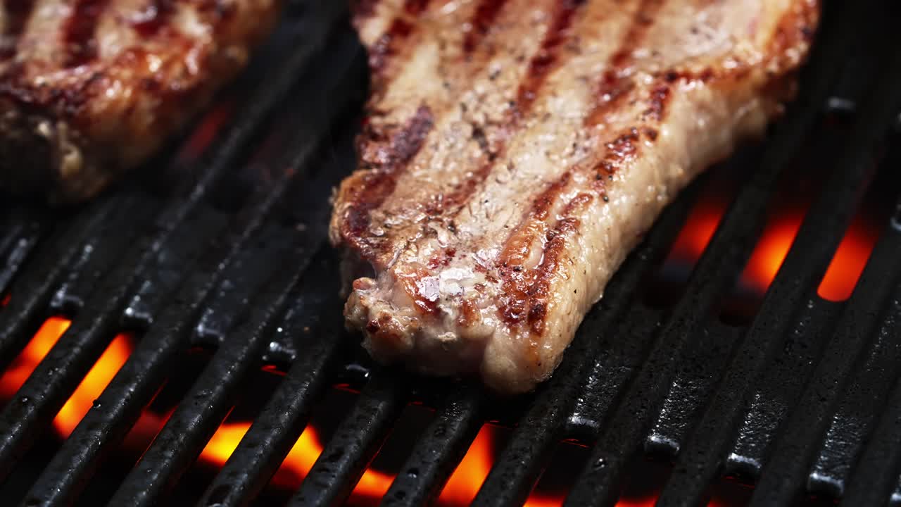 bistec cocinado en una parrilla de barbacoa caliente en llamas con llamas en el fondo