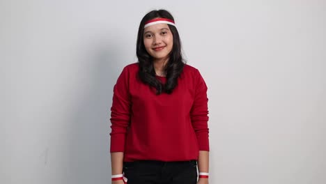 Pretty young Asian woman giving salute celebrate Indonesian independence day on 17 August isolated over white background