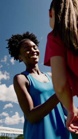 happy female tennis players on an outdoor court