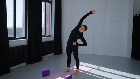 woman doing yoga stretches in studio