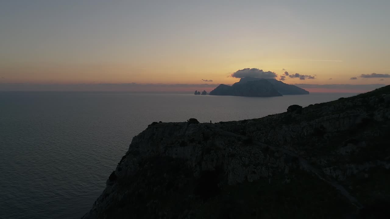 a guy is watching the sunset after an hard path