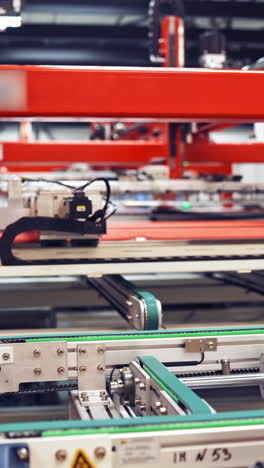 industrial robot working at solar pannels production factory,conveyor tracking controler of robotic hand. green energy concept. vertical video