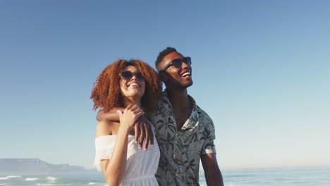 african american couple walking side by side at beach