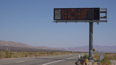 a highway sign warns of extreme heat and to save water during severe drought in california