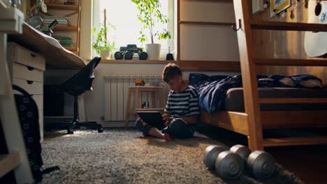 boy using tablet in his bedroom