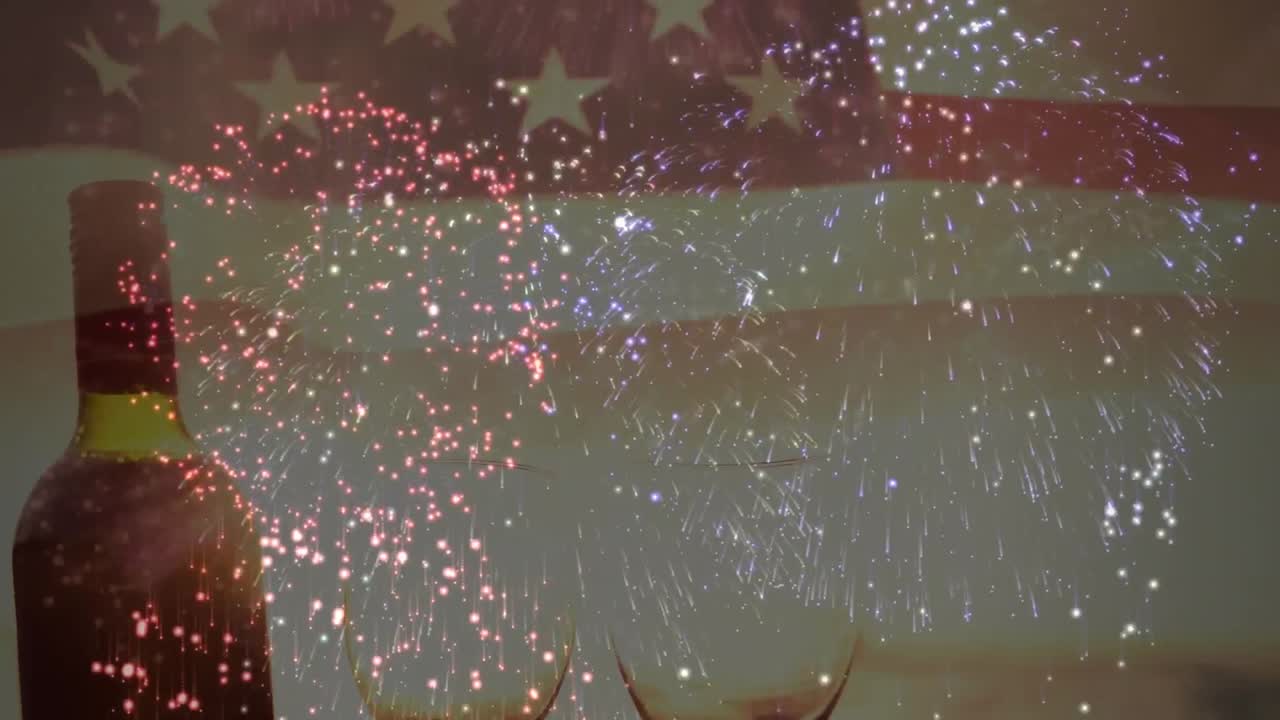 Animation of fireworks over bottle of wine and glasses and flag of united states of america