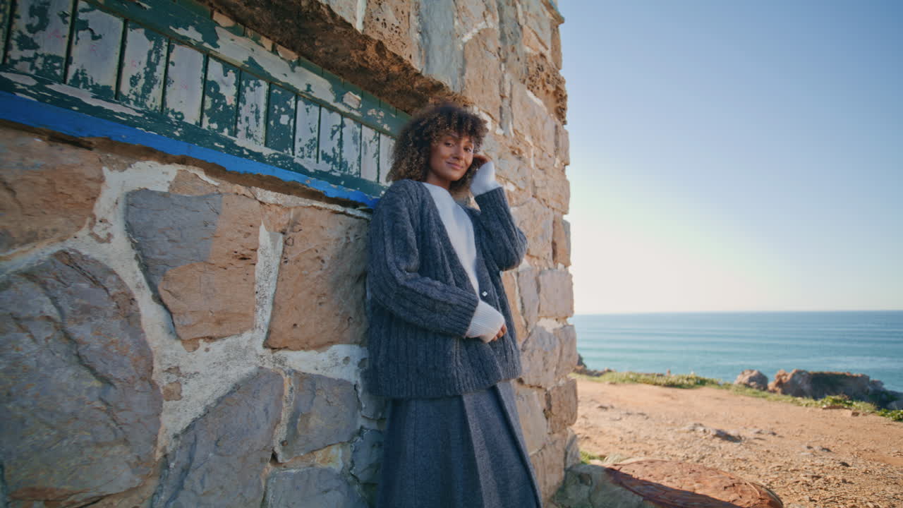 Romantic lady leaning castle wall. Dreaming smiling woman looking camera posing