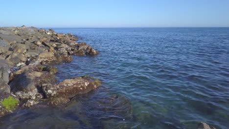 sea cliff rocks at sunny day aerial view